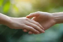 Two hands gently holding each other, symbolizing support and empathy in a psychology counselling